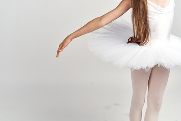 A small ballerina in a pack and an outstretched pen on a gray background