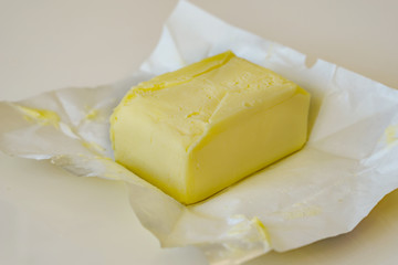 Close up of open pack of butter on white backgraund. Shallow depth of focus.