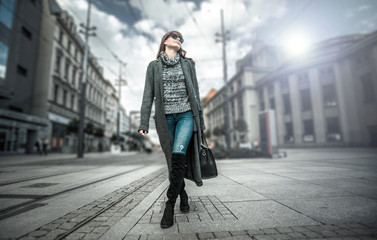 Casual fashion urban scene, trendy woman in coat walking on the street