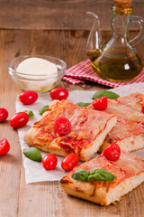 Italian pizza with cheese, tomatoes and fresh basil.