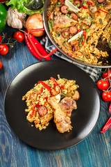 Traditional paella with chicken legs, sausage chorizo and vegeta