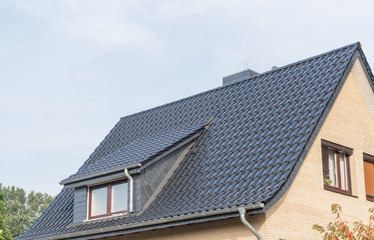 Dach eines Hauses mit Gaube und Schornstein