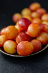 Ripe and beautiful wild plum fruits over black background.