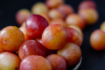 Ripe and beautiful wild plum fruits over black background.