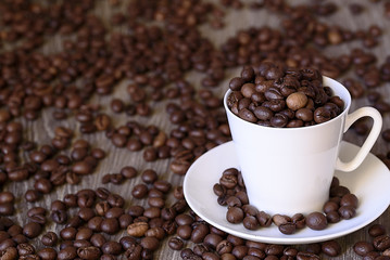 Coffee concept: fried coffee beans in porcelain white coffee cup