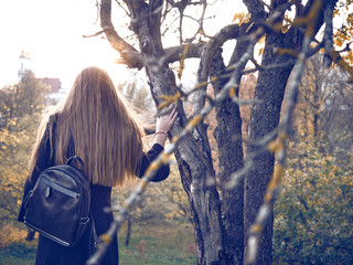 A young stranger strolls through the autumn apple orchard.