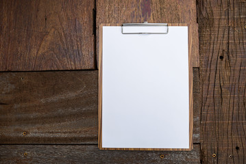 Blank paper on wood clipboard on old wood background