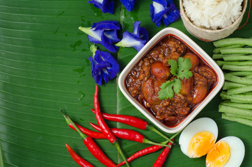 Thai Northern Style Pork and Tomato Chili Relish with sticky rice and vegetables on banana leaf, Nam Prik Aawng, Nam Prik Ong, Bruschetta fried with pork, oil and chilli
