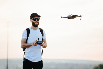 Man operating the drone by remote control and having fun