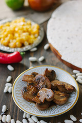 Roasted mushrooms on white ceramic plate on kitchen table.