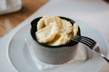 Vareniki - russian vegetarian dumplings on ceramic bowl.