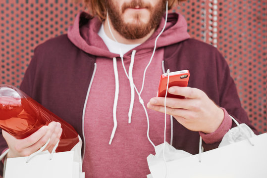 Skateboarder using smart phone with his soda