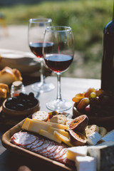 wine with wooden plate of sliced snacks