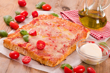 Italian pizza with cheese, tomatoes and fresh basil.