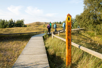 Wanderer auf einem Plankenweg zur Hohen Düne