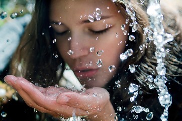 Portrait of beautiful brunette girl drinking spring water