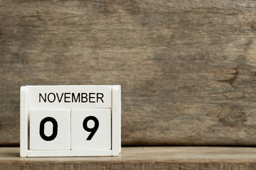 White block calendar present date 9 and month November on wood background