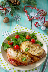 Baked chicken meat stuffed with tomatoes and cheese on a festive Christmas table.