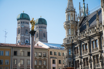 Fototapeta na wymiar Golden sculpture of St. Mary with the Church of Our Lady. View from Marienplatz in Munich, Germany