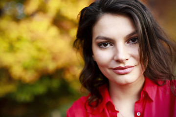 Fototapeta premium Beautiful young brunette enjoys a sunny day of autumn in nature