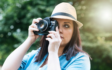 Portrait of pretty young woman using a camera, light effect