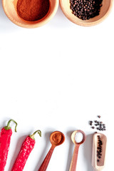 spices in wooden spoon on white background top view