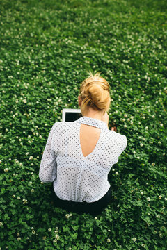 Woman with her computer sitting on the grass