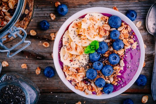 healthy smoothie bowl with granola, banana and fresh blueberries