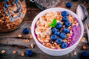 healthy smoothie bowl with granola, banana and fresh blueberries