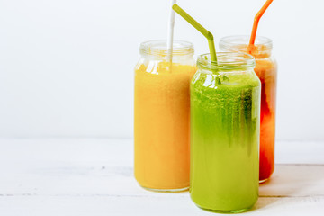 Fresh detox juices in glass bottles on white background