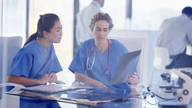  Hospital doctors in a meeting discussing patient x-ray & medical notes