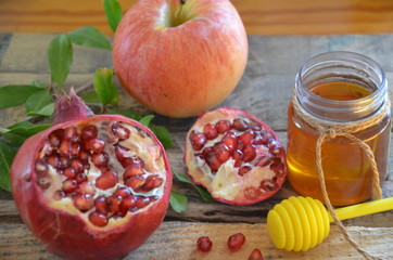 Honey, apple and pomegranate for traditional holiday symbols rosh hashanah (jewesh holiday) on black background