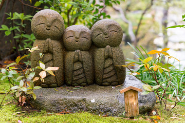 Japanese smile stone buddha monk statue (Jizo Bosatsu), Japanese believe that they can help protect tourists and children to survive, Hasedera Temple, Kamakura, Japan
