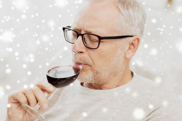senior man drinking red wine from glass