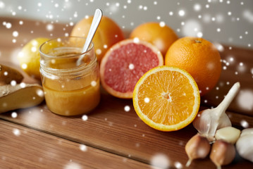 honey, citrus fruits, ginger and garlic on wood