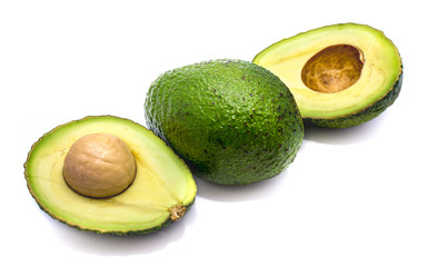 Whole avocado (Persea americana, alligator pear) and its halves with a stone isolated on white background