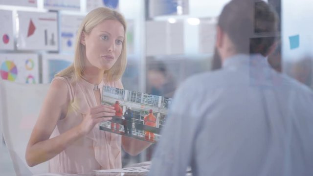  Creative business man & woman in a meeting looking at photos & shaking hands