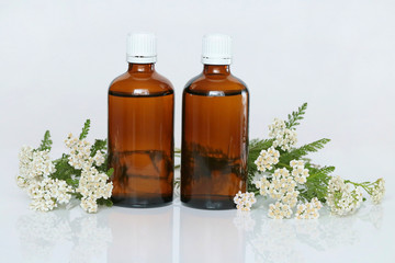 Yarrow Tincture.   yarrow oil in two brown glass bottles and yarrow flowers on . Natural pharmacy. Yarrow Oil
