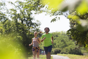Naklejka na ściany i meble Healthy, fit and sportive couple running in park