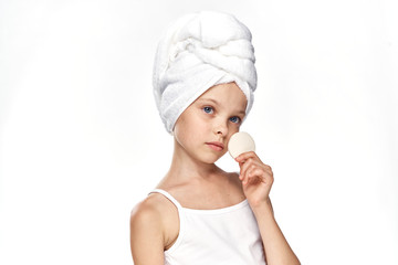 little girl in a towel and with a sponge in her hand