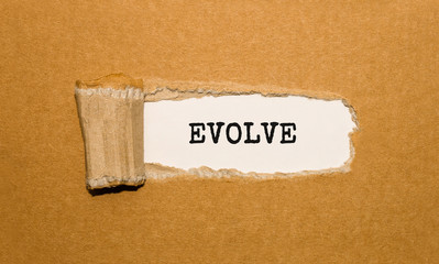 The text EVOLVE appearing behind torn brown paper