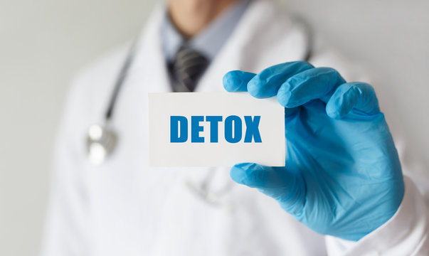 Doctor holding a card with text DETOX, medical concept