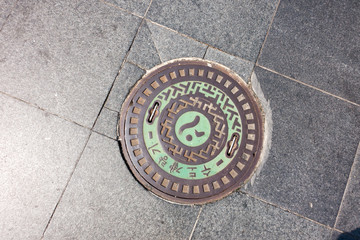 Schachtdeckel / Gullideckel mit koreanischen Schriftzeichen in Seoul, Korea.