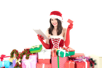 beautiful santa girl wearing santa claus clothes costume sitting near Gift Box holding  tablet phone and credit card for online purchase  over white background