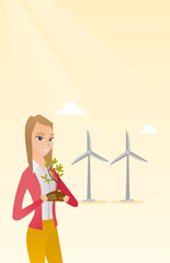 Young caucasian female worker of wind farm. Woman holding in hands green small plant in soil on the background of wind turbines. Green energy concept. Vector flat design illustration. Vertical layout.