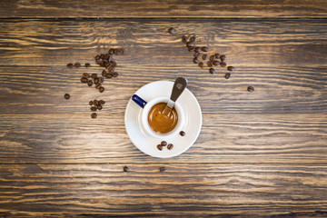 Caffe espresso su bancone in legno con chicchi di caffe