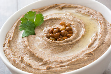 Close up lentil hummus in bowl on wood