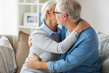 close up of happy senior couple hugging at home