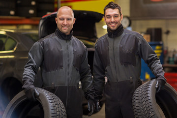 auto mechanics changing car tires at workshop