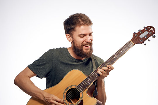 man smiling and playing the guitar on a white background